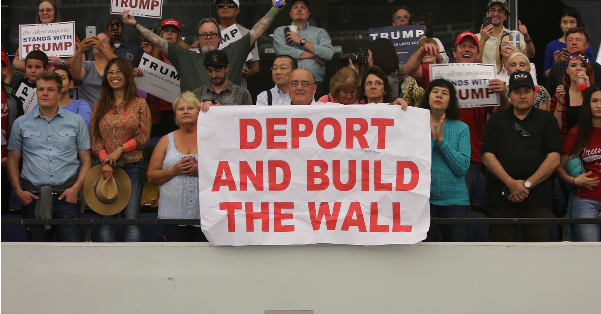 Trump supporters with sign 'Deport and build the wall'