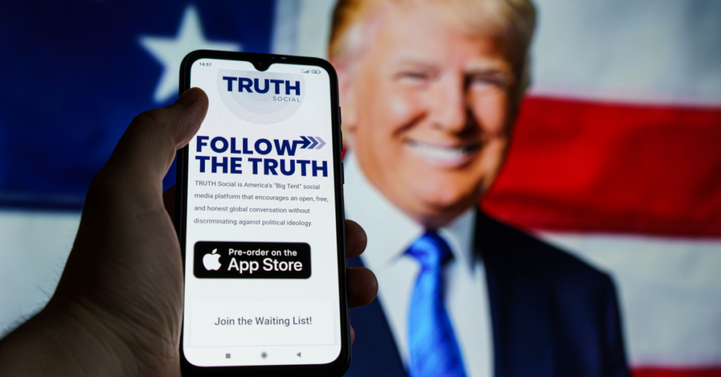 Phone with Truth Social interface on mobile against background of Donald Trump image