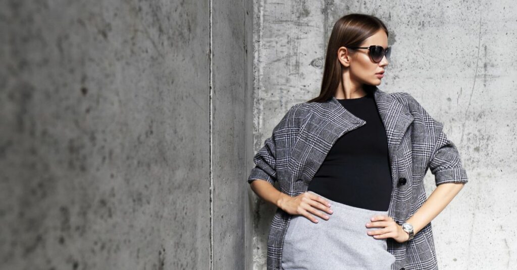 Female model standing against cement wall